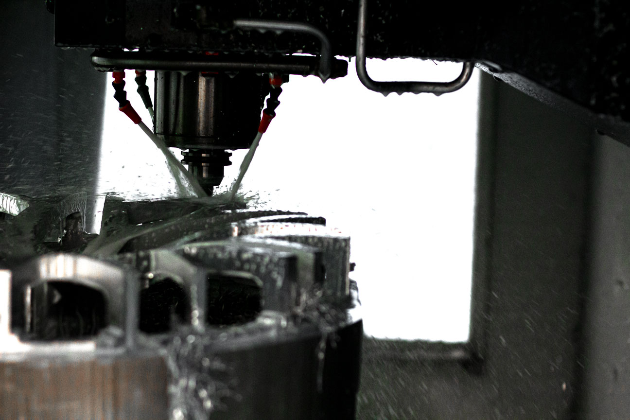 CNC mill cutting a wheel face under coolant